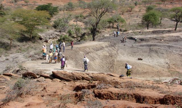 Manual construction of a small dam requires community action: soil is transported in bags, piled up and compacted layer by layer
