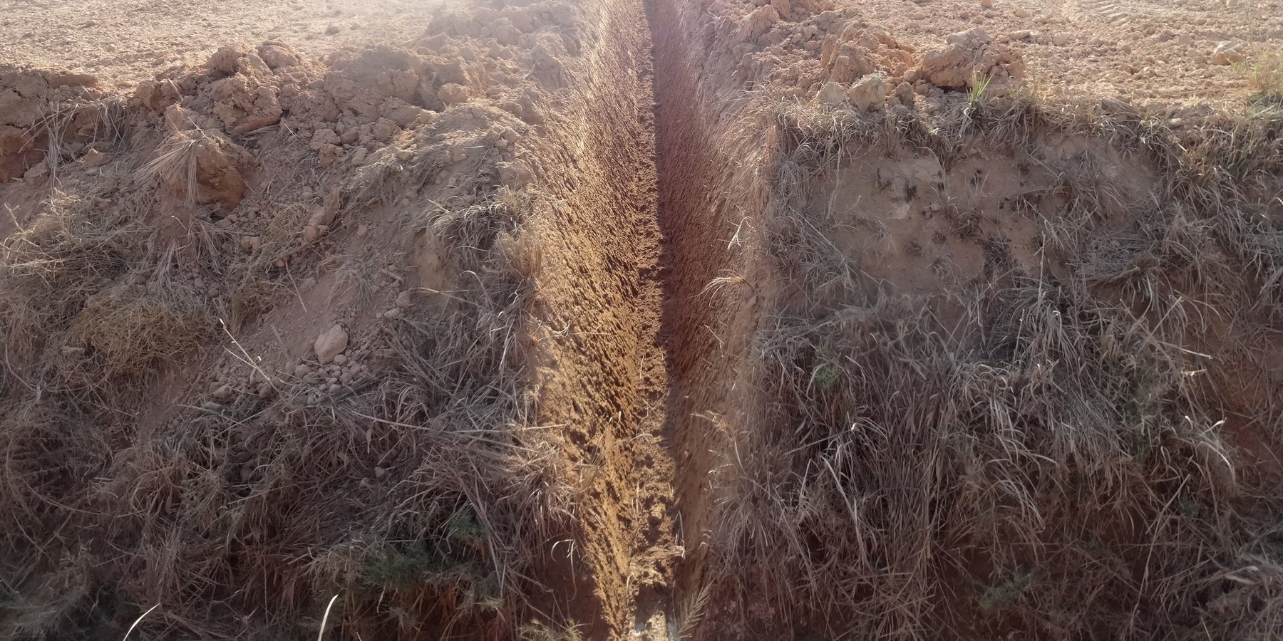 Drainage ditch constructed in a field with a problem of drainage and high calcium carbonate content.